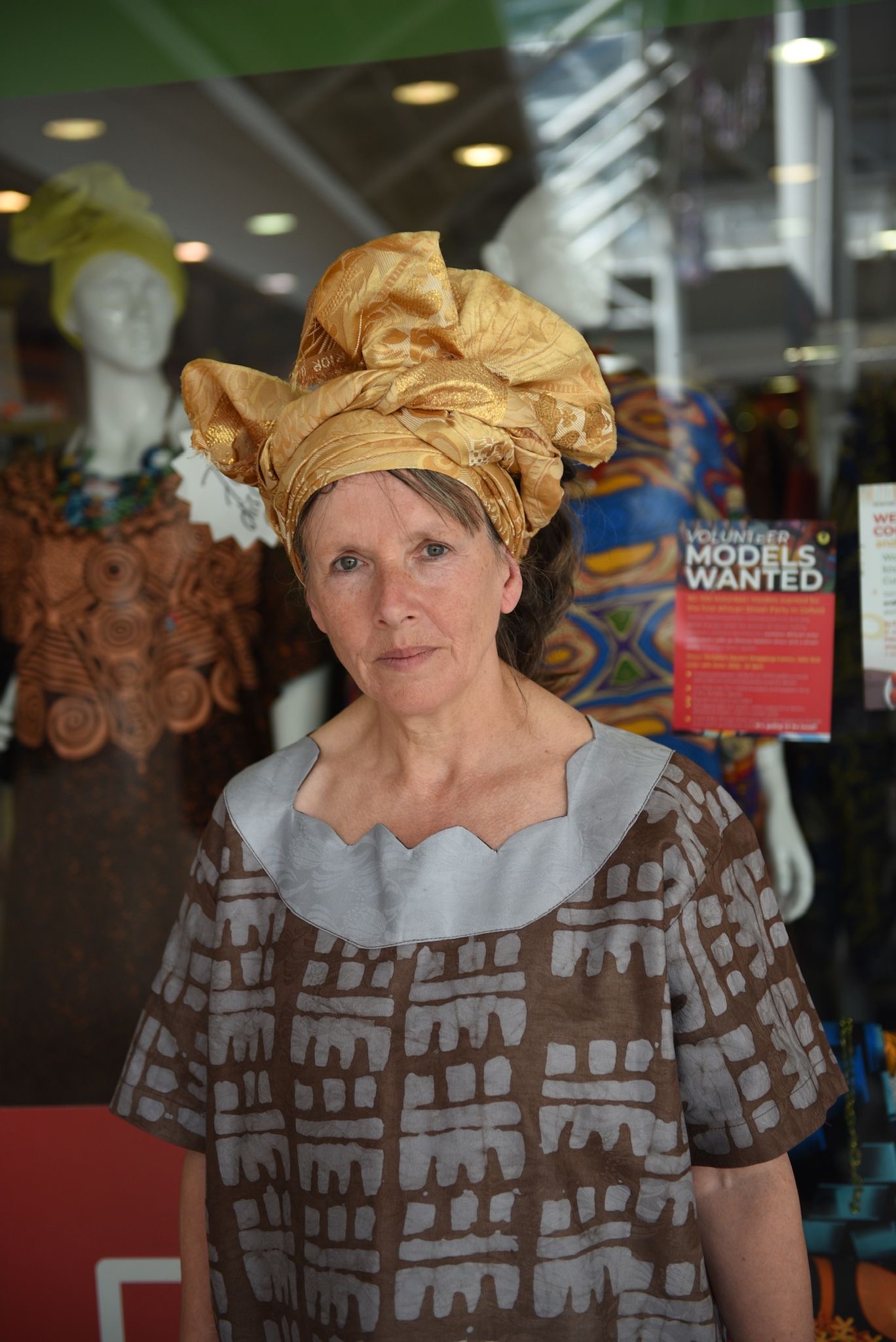 Guest wearing a gold-patterned headwrap and traditional attire
