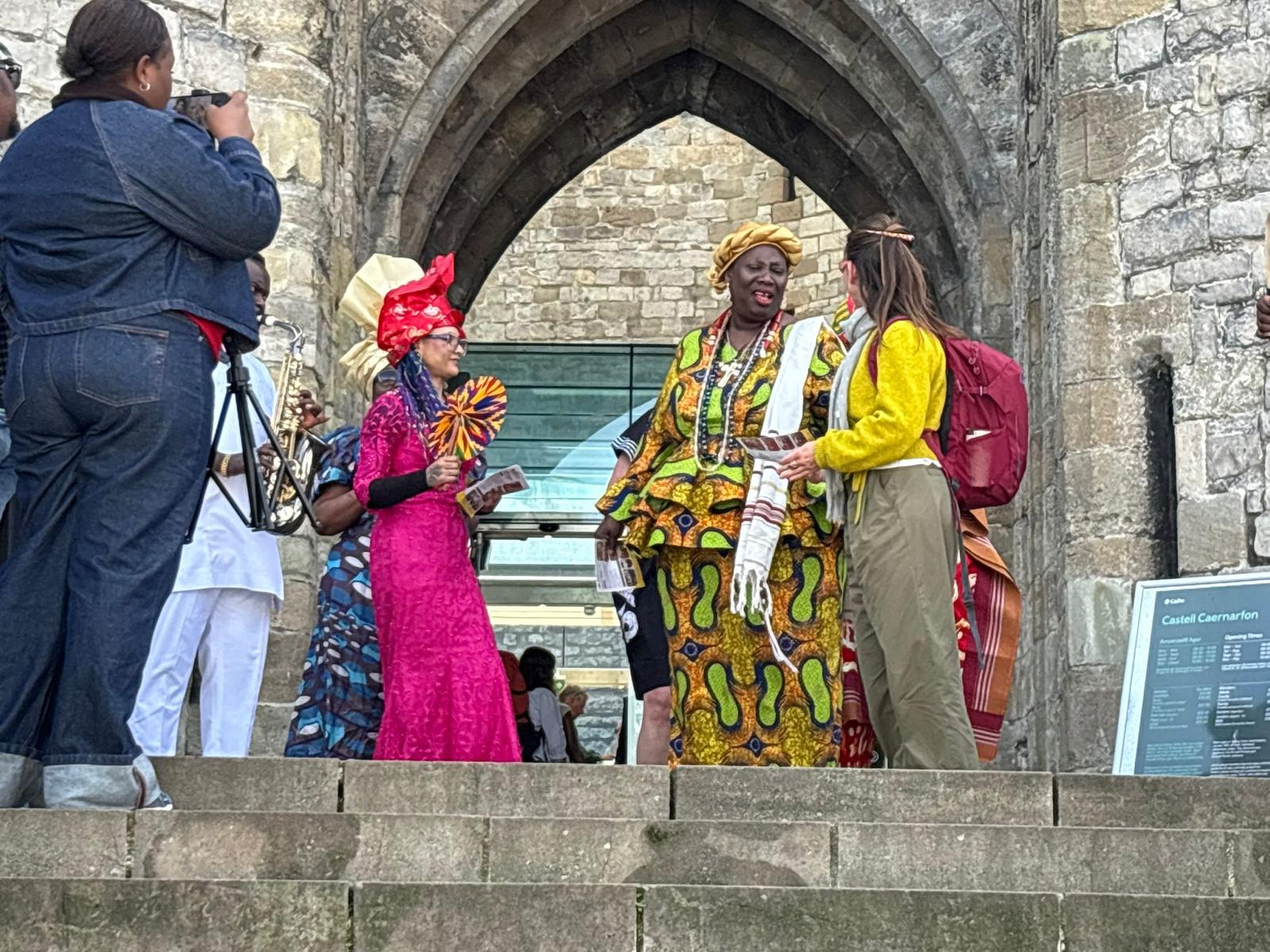 Guests speaking beneath a stone arch
