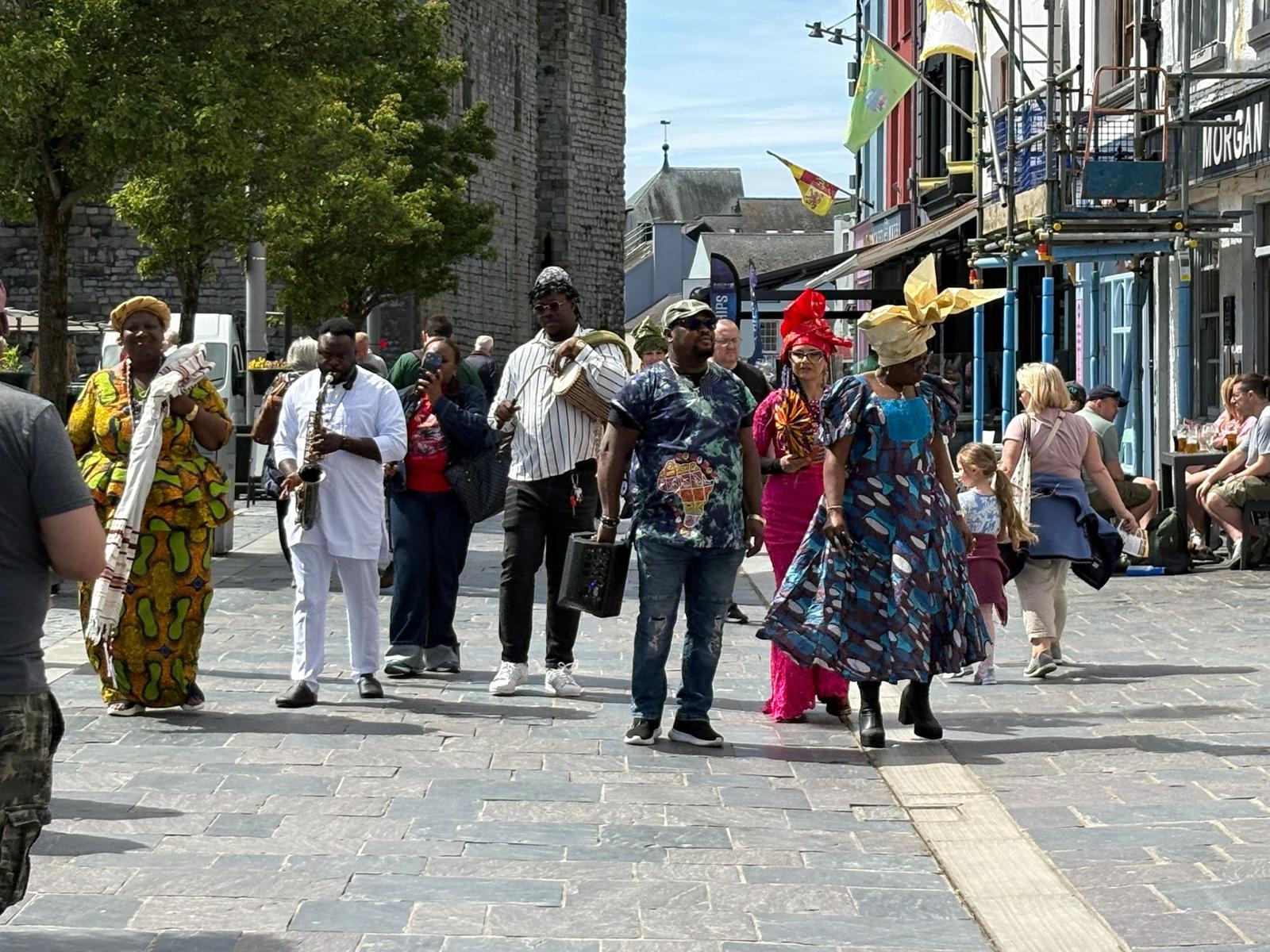 Community parade moving through a pedestrian street